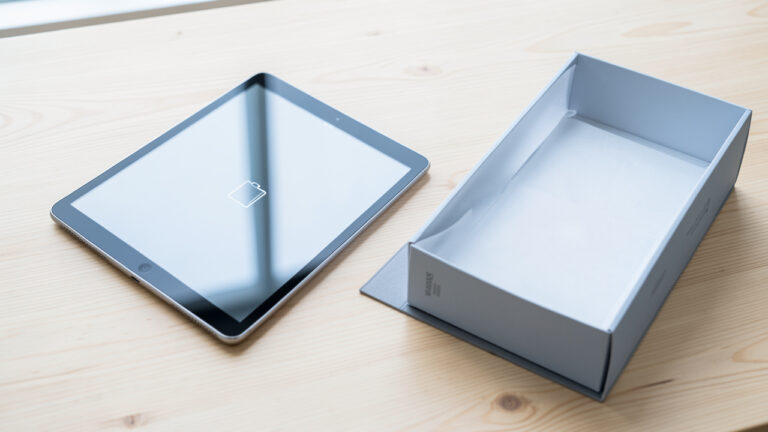 Tablette reconditionnée inspectée avec soin sur un bureau, accompagnée de ses accessoires et de son emballage protecteur.